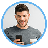 Young man smiling as he uses his mobile phone to pay a medical bill.