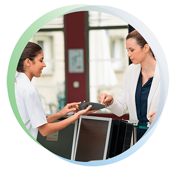 Office administrator holds a digital payment device for a patient to make a copayment for her doctor visit.